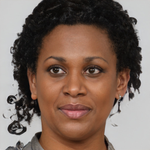 Joyful black adult female with short  brown hair and brown eyes