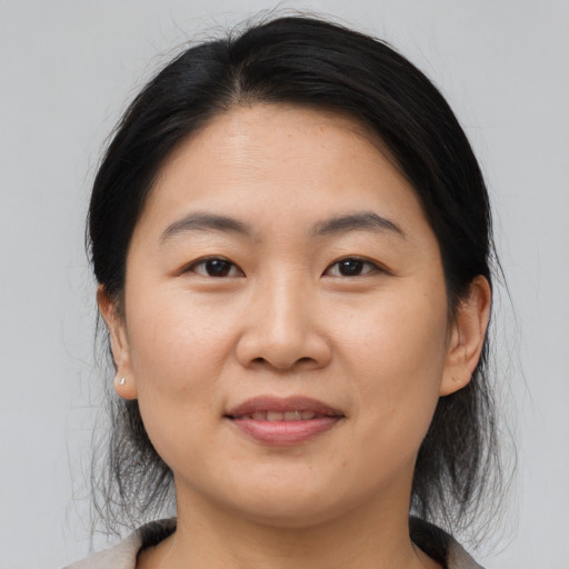 Joyful asian young-adult female with medium  brown hair and brown eyes