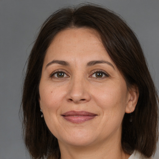 Joyful white adult female with medium  brown hair and brown eyes