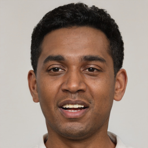 Joyful black young-adult male with short  black hair and brown eyes