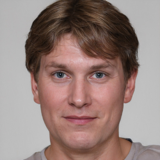 Joyful white adult male with short  brown hair and grey eyes