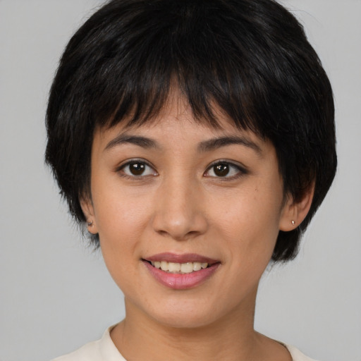 Joyful asian young-adult female with medium  brown hair and brown eyes