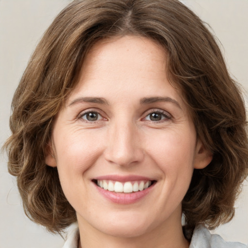 Joyful white young-adult female with medium  brown hair and green eyes