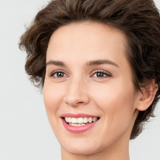 Joyful white young-adult female with medium  brown hair and green eyes