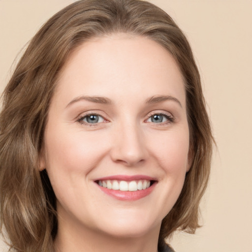 Joyful white young-adult female with medium  brown hair and green eyes