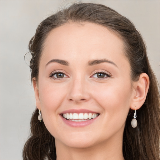 Joyful white young-adult female with long  brown hair and blue eyes