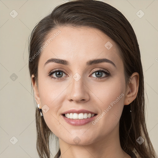 Joyful white young-adult female with long  brown hair and grey eyes