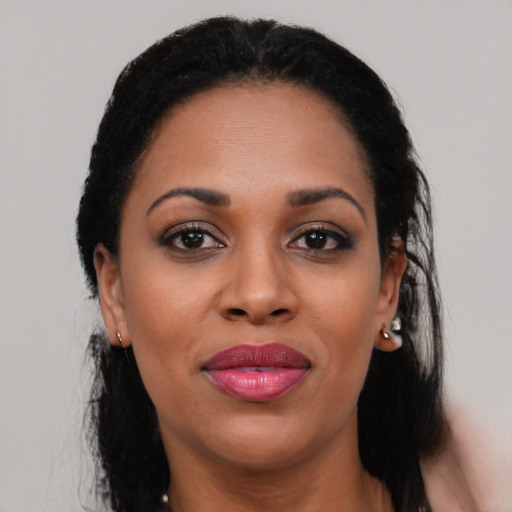 Joyful black adult female with long  black hair and brown eyes