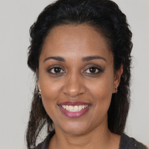 Joyful black young-adult female with medium  brown hair and brown eyes