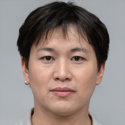 Joyful asian adult male with short  brown hair and brown eyes