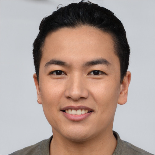 Joyful asian young-adult male with short  black hair and brown eyes
