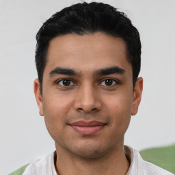 Joyful latino young-adult male with short  black hair and brown eyes