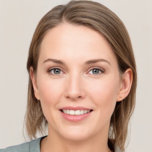 Joyful white young-adult female with medium  brown hair and grey eyes