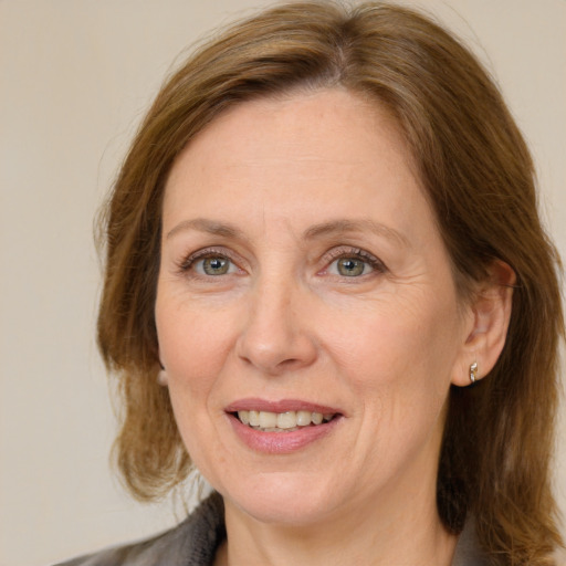 Joyful white adult female with medium  brown hair and grey eyes