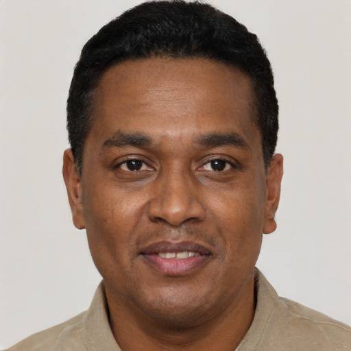 Joyful black adult male with short  black hair and brown eyes