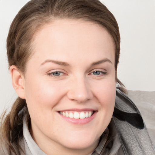 Joyful white young-adult female with long  brown hair and blue eyes