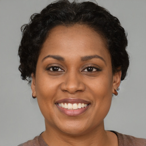 Joyful black young-adult female with short  brown hair and brown eyes