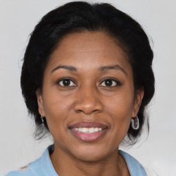 Joyful black adult female with medium  brown hair and brown eyes