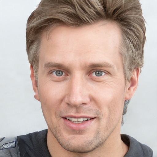 Joyful white adult male with short  brown hair and grey eyes