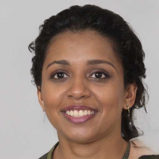Joyful black young-adult female with short  brown hair and brown eyes