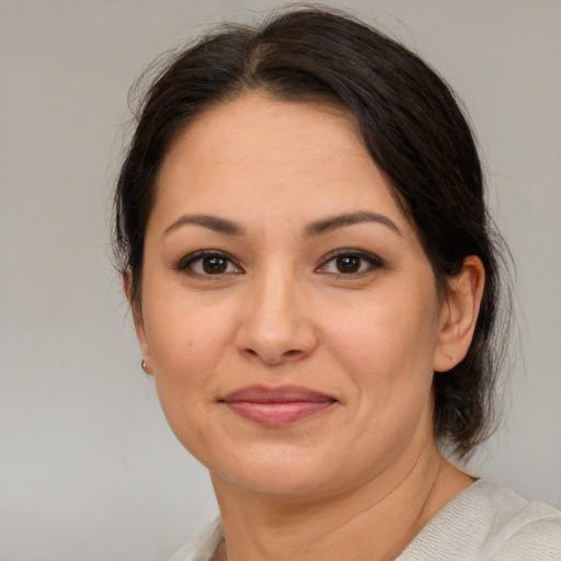 Joyful latino adult female with medium  brown hair and brown eyes