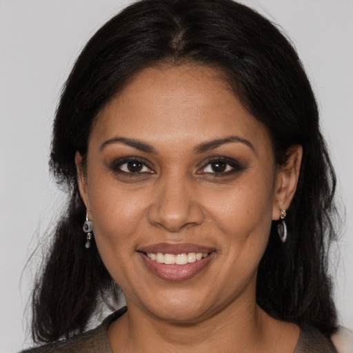 Joyful black adult female with long  brown hair and brown eyes