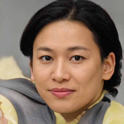 Joyful asian young-adult female with short  brown hair and brown eyes