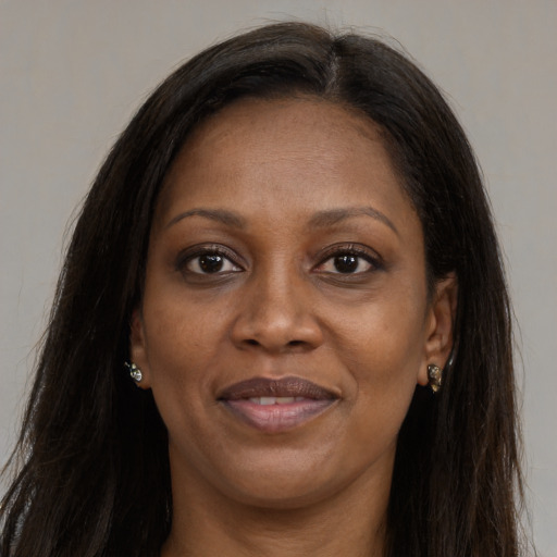 Joyful black adult female with long  brown hair and brown eyes