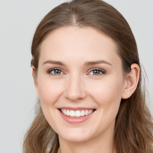 Joyful white young-adult female with long  brown hair and grey eyes