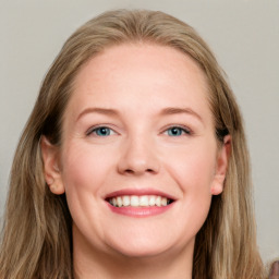 Joyful white young-adult female with long  brown hair and blue eyes