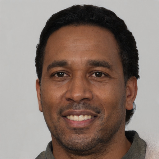 Joyful latino adult male with short  black hair and brown eyes