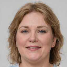 Joyful white adult female with medium  brown hair and green eyes