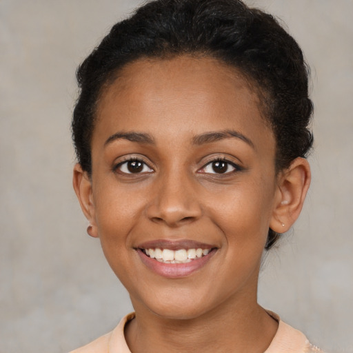 Joyful black young-adult female with short  brown hair and brown eyes