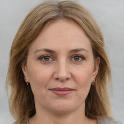 Joyful white adult female with medium  brown hair and grey eyes