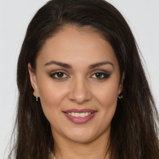 Joyful white young-adult female with long  brown hair and brown eyes