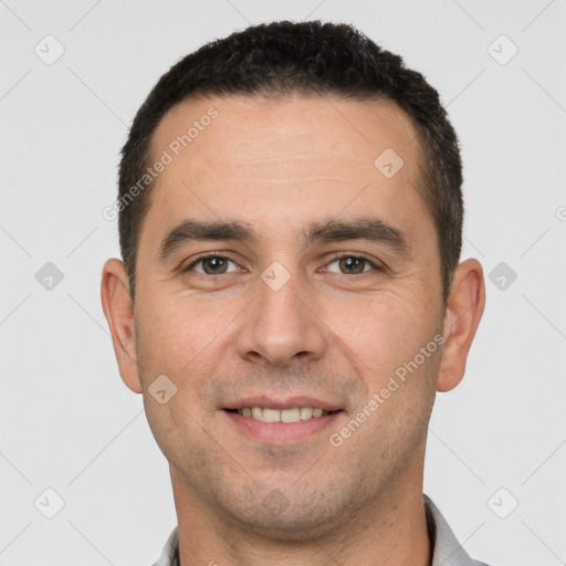 Joyful white young-adult male with short  black hair and brown eyes