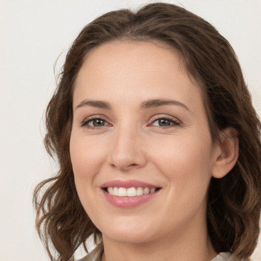 Joyful white young-adult female with long  brown hair and grey eyes