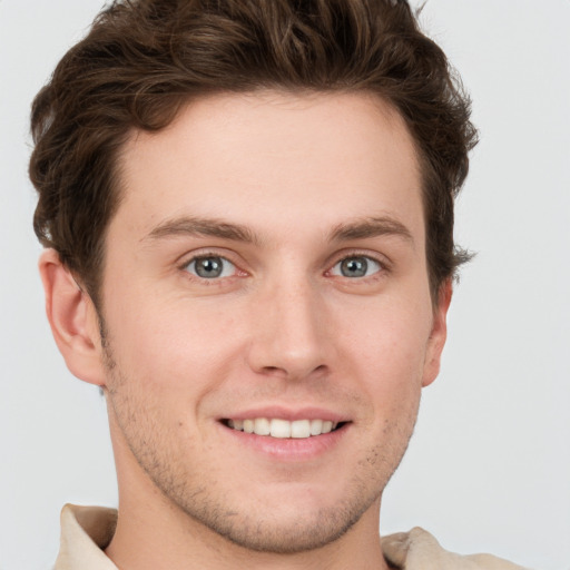 Joyful white young-adult male with short  brown hair and grey eyes