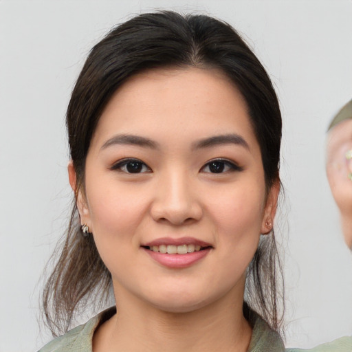 Joyful asian young-adult female with medium  brown hair and brown eyes