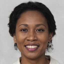 Joyful black adult female with medium  brown hair and brown eyes