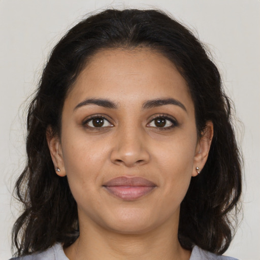 Joyful latino young-adult female with medium  brown hair and brown eyes