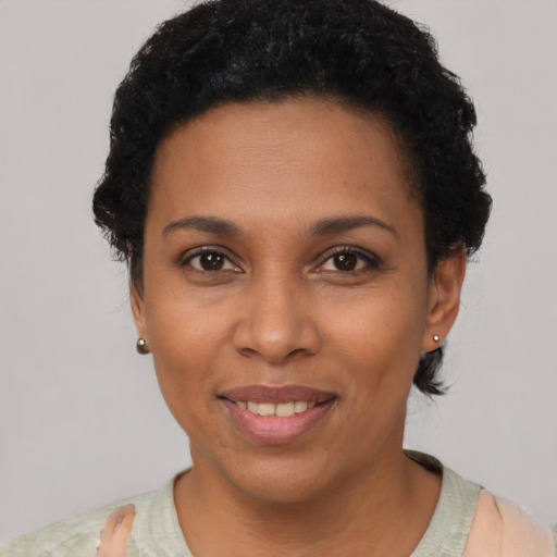 Joyful black young-adult female with short  black hair and brown eyes