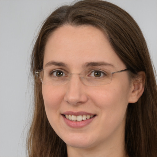 Joyful white adult female with long  brown hair and grey eyes