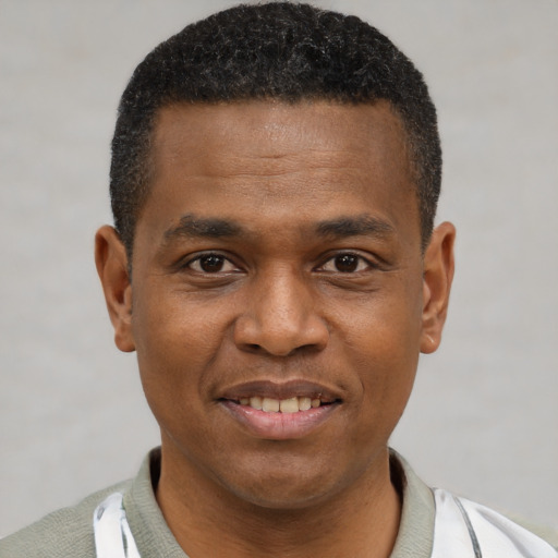Joyful black young-adult male with short  brown hair and brown eyes
