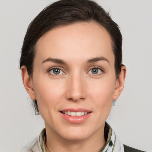 Joyful white young-adult female with medium  brown hair and grey eyes