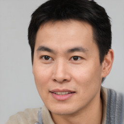 Joyful asian young-adult male with short  brown hair and brown eyes