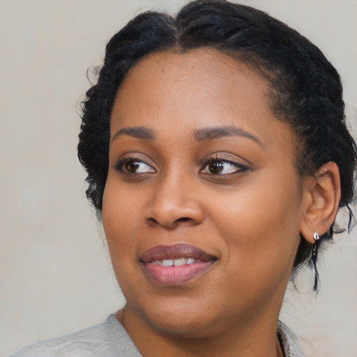 Joyful black young-adult female with medium  black hair and brown eyes