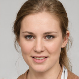 Joyful white young-adult female with medium  brown hair and grey eyes