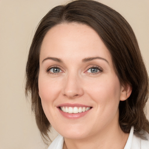 Joyful white young-adult female with medium  brown hair and green eyes