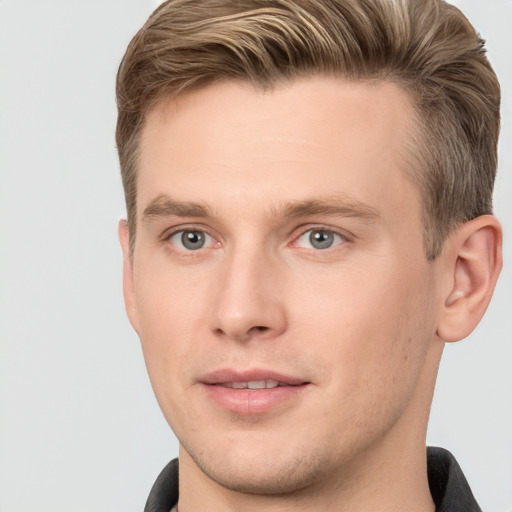 Joyful white young-adult male with short  brown hair and grey eyes